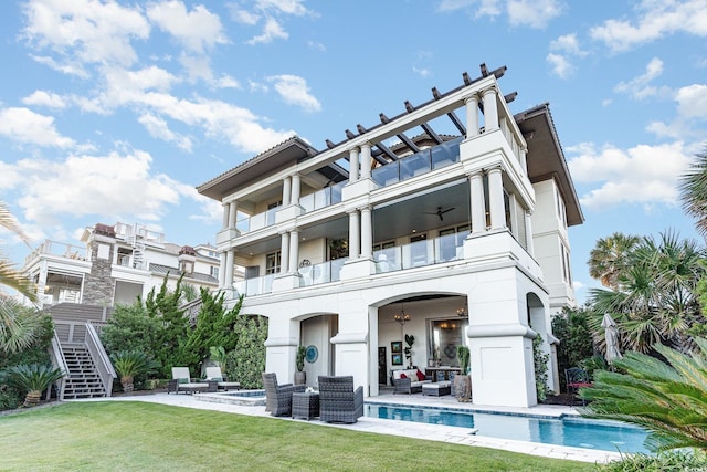 rear view of property featuring ceiling fan, a yard, an outdoor hangout area, a balcony, and a patio