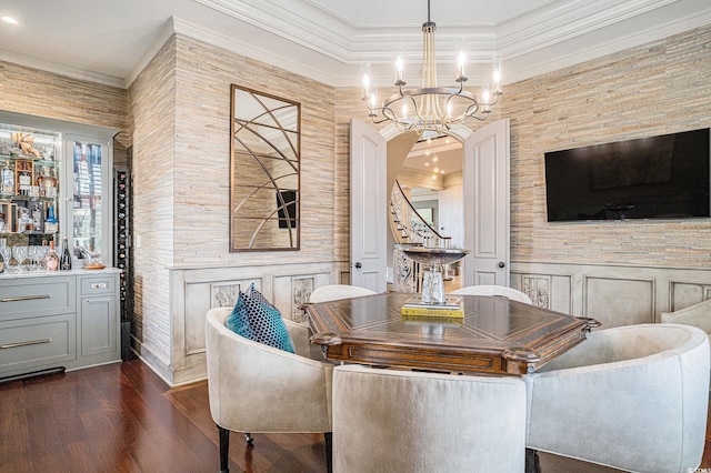 dining space with ornamental molding, an inviting chandelier, and dark wood-type flooring