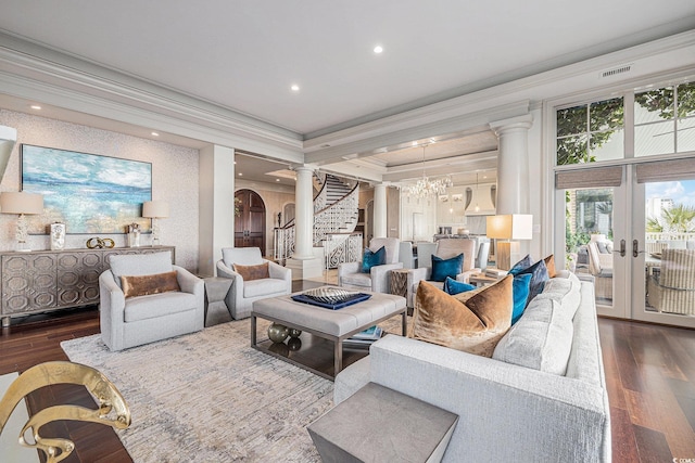 living room with french doors, crown molding, dark wood-type flooring, and a notable chandelier