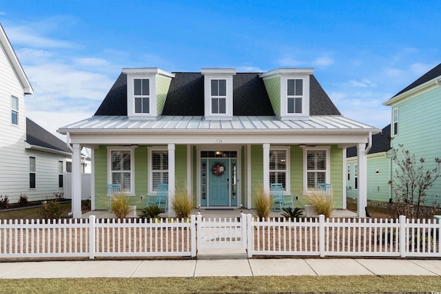 3126 White Jasmine Dr, Little River, SC 29566 - view of front of house with a porch, a standing seam roof, a fenced front yard, and a metal roof