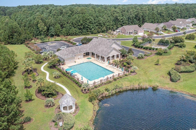 aerial overview of property's location with a forest, a pool, and a large body of water