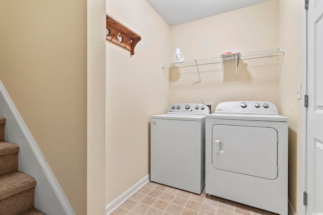 washroom with washing machine and clothes dryer and baseboards