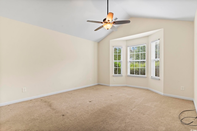 spare room with carpet, baseboards, a ceiling fan, and vaulted ceiling