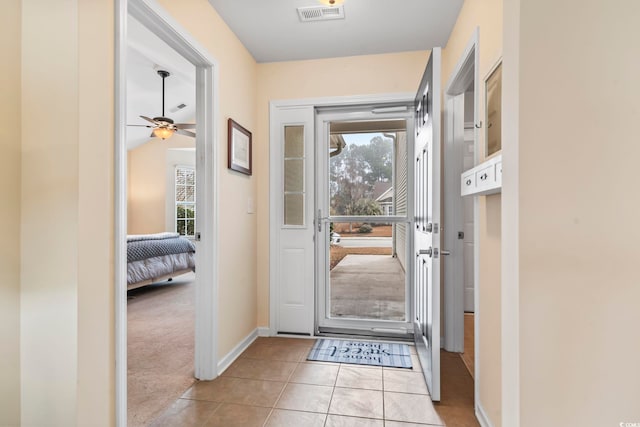 entryway featuring plenty of natural light, light tile patterned flooring, baseboards, and a ceiling fan