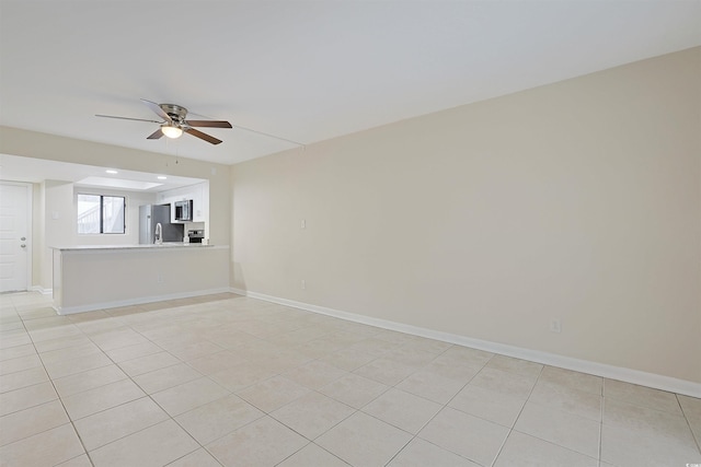 tiled empty room featuring ceiling fan