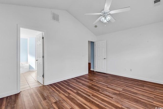 unfurnished bedroom with connected bathroom, ceiling fan, high vaulted ceiling, and dark hardwood / wood-style floors