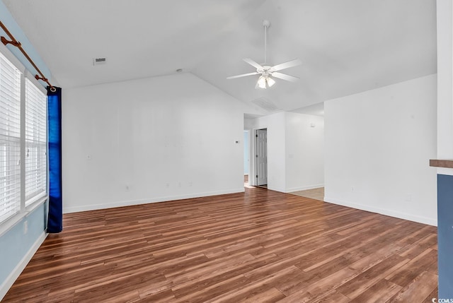 empty room featuring dark hardwood / wood-style floors, ceiling fan, a wealth of natural light, and vaulted ceiling