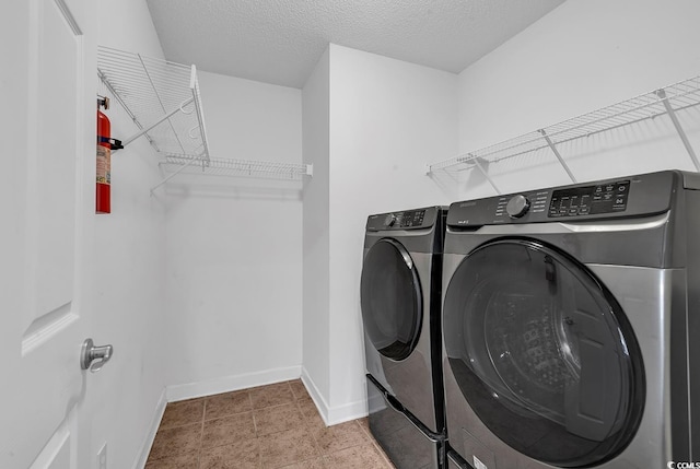 laundry area featuring washing machine and dryer and a textured ceiling