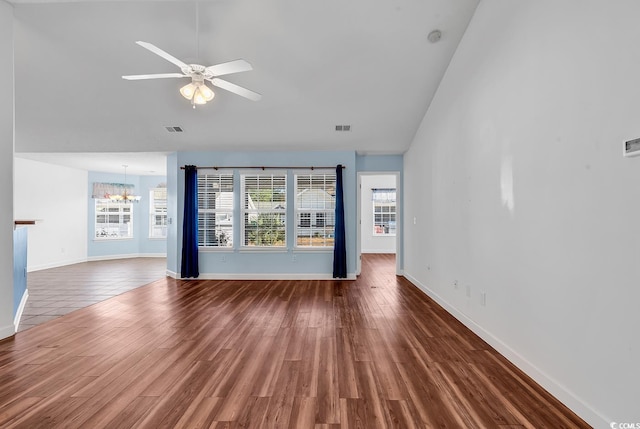 unfurnished living room featuring ceiling fan with notable chandelier and wood-type flooring