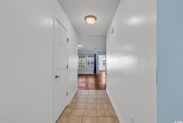 hallway featuring a textured ceiling and light hardwood / wood-style flooring