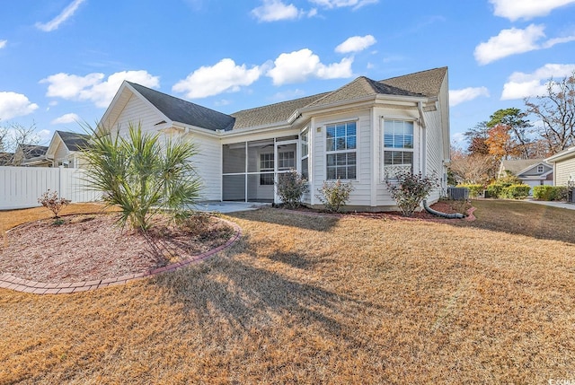 view of front of house with a sunroom and a front lawn