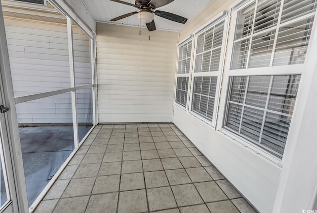 unfurnished sunroom with ceiling fan