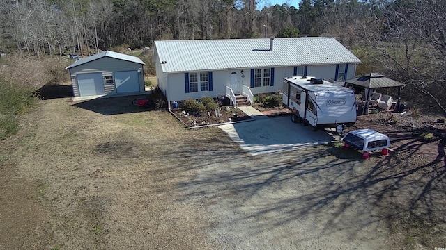 view of front of house with a garage and an outbuilding