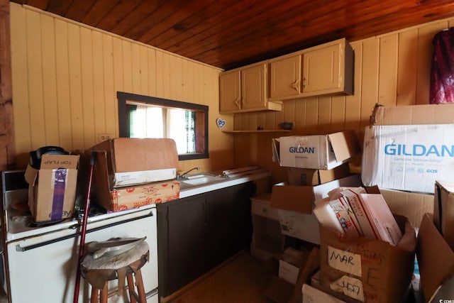 kitchen with wooden walls, sink, and wooden ceiling