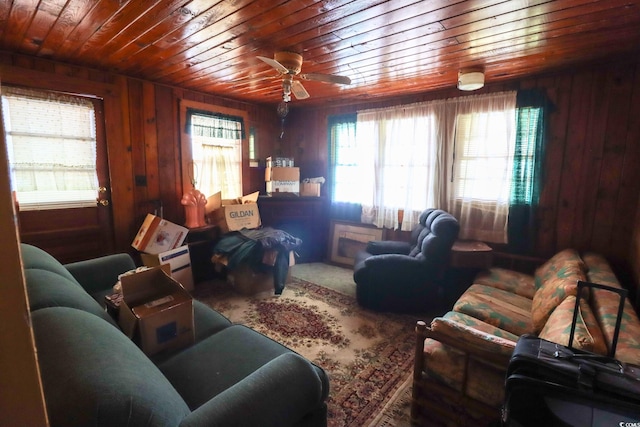 living room with ceiling fan, wood walls, and wood ceiling