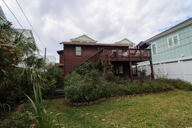 rear view of house with a lawn and a deck