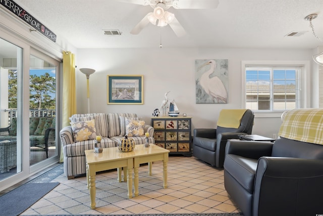 living room featuring a textured ceiling and ceiling fan