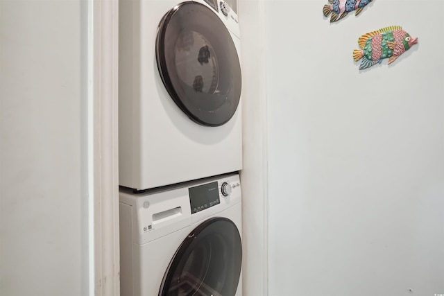 clothes washing area featuring stacked washing maching and dryer