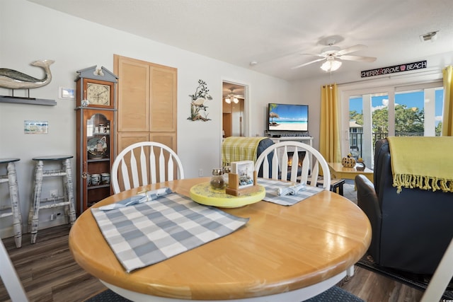 dining space with ceiling fan and dark hardwood / wood-style floors