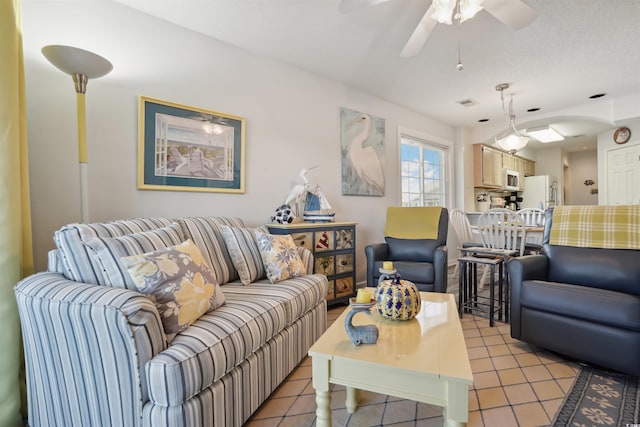 tiled living room with a textured ceiling and ceiling fan