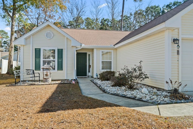 ranch-style home featuring a front lawn and a garage