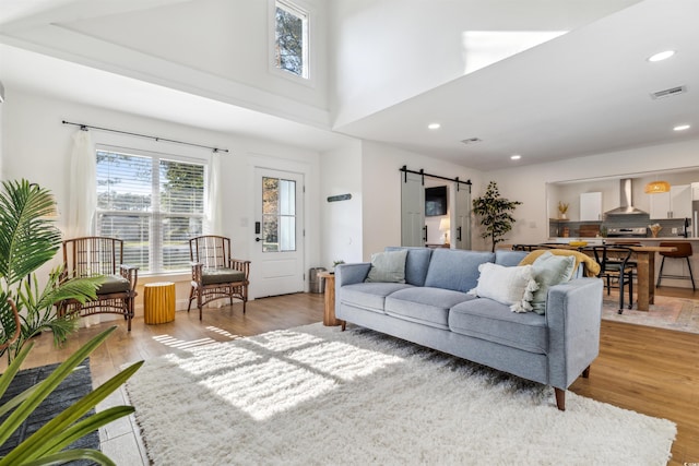 living room featuring a barn door and light hardwood / wood-style flooring