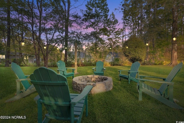 yard at dusk featuring an outdoor fire pit