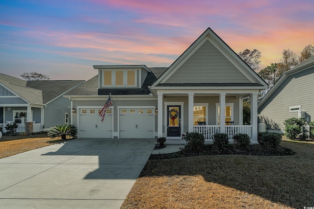 view of front of property with a porch, a garage, and a yard