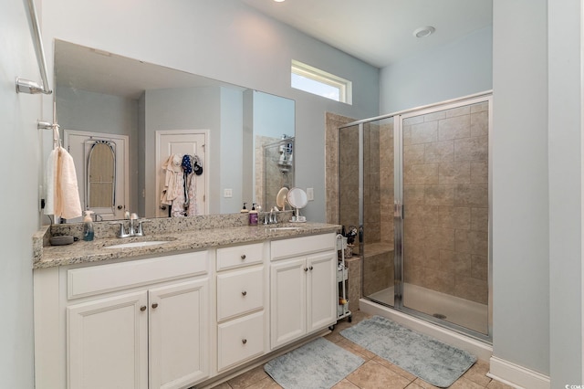 bathroom with tile patterned floors, vanity, and walk in shower