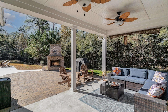 view of patio / terrace with an outdoor living space with a fireplace and ceiling fan