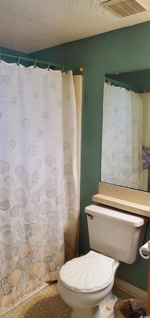 bathroom with toilet and a textured ceiling