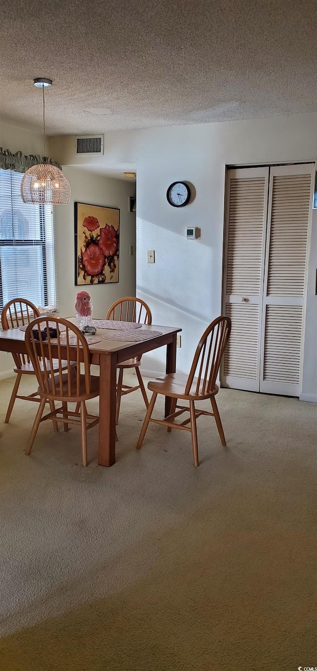 dining space with carpet flooring and a textured ceiling