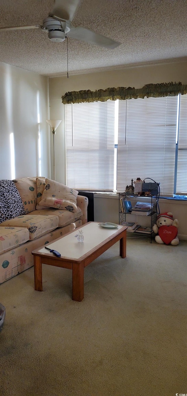 carpeted living room with a textured ceiling and ceiling fan