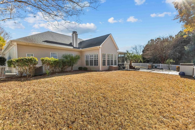 back of property featuring a yard, a patio, and a sunroom