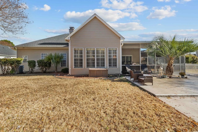 back of house featuring a sunroom, a patio area, and a lawn