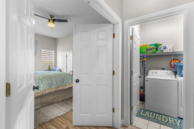 laundry area with washer and clothes dryer, ceiling fan, light hardwood / wood-style floors, and a textured ceiling