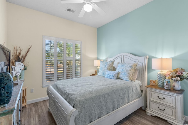 bedroom with ceiling fan and dark hardwood / wood-style floors