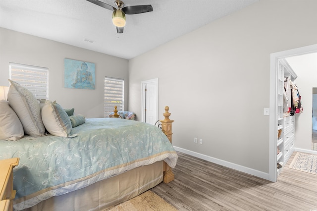 bedroom with multiple windows, light hardwood / wood-style flooring, and ceiling fan