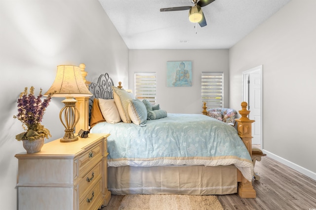 bedroom with ceiling fan, light wood-type flooring, and a textured ceiling