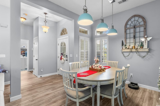 dining space featuring washer and dryer and light wood-type flooring