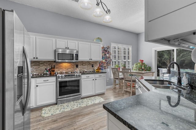 kitchen with light hardwood / wood-style floors, white cabinetry, and stainless steel appliances