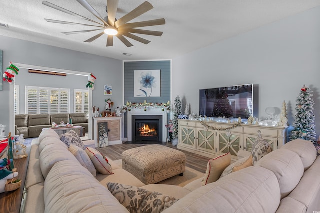 living room with a textured ceiling, light hardwood / wood-style floors, and ceiling fan