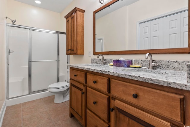 bathroom featuring tile patterned flooring, vanity, toilet, and a shower with door