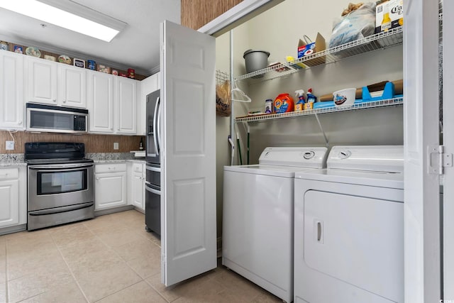 washroom featuring washer and clothes dryer and light tile patterned floors