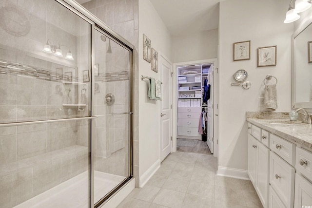 bathroom featuring tile patterned flooring, vanity, and an enclosed shower