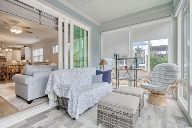 sunroom / solarium with ceiling fan with notable chandelier