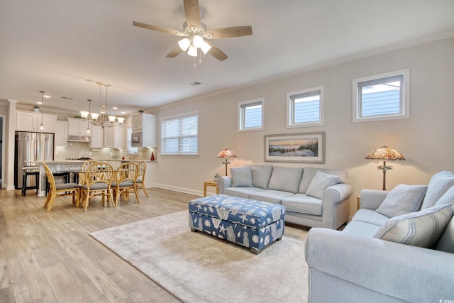 living room featuring ceiling fan with notable chandelier, light wood-type flooring, and ornamental molding