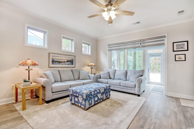 living room with ceiling fan, ornamental molding, and light wood-type flooring