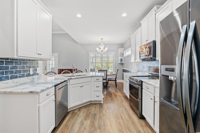 kitchen featuring white cabinetry, stainless steel appliances, light hardwood / wood-style flooring, crown molding, and decorative backsplash