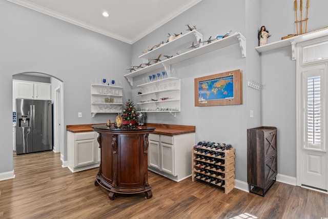 bar with butcher block counters, stainless steel fridge with ice dispenser, white cabinets, and dark hardwood / wood-style floors